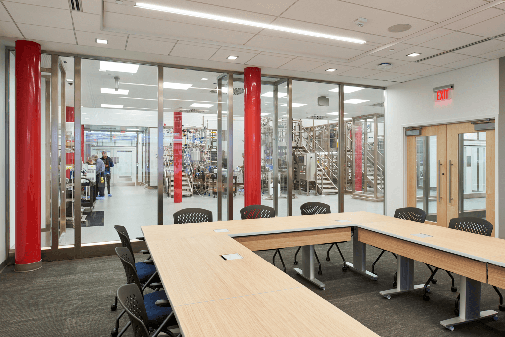 Conference table with window looking into manufacturing equipment