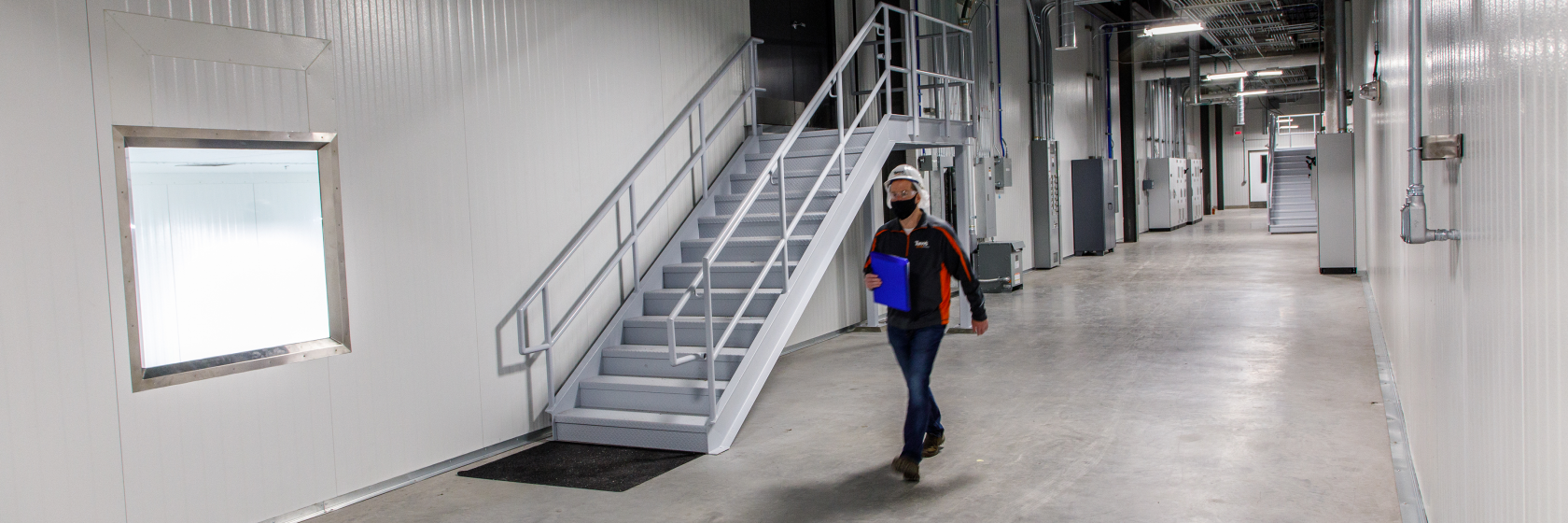 man walking in touring corridors at Tuffy’s Treat Company